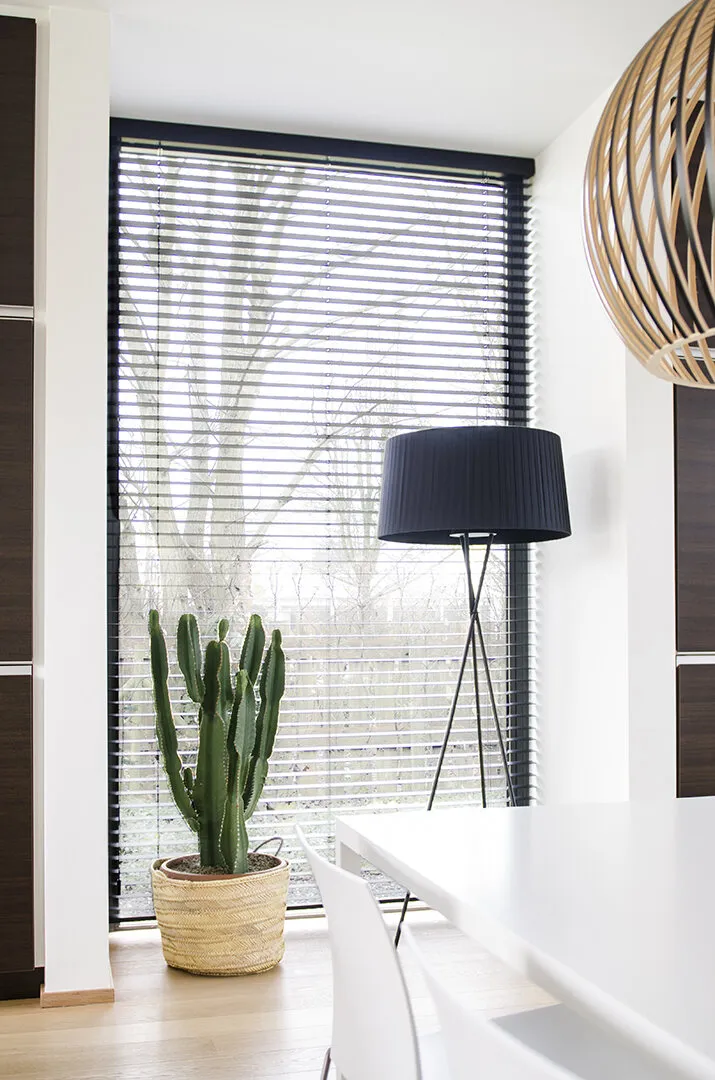 Witte aluminium jaloezieën in een lichte, moderne woonkamer