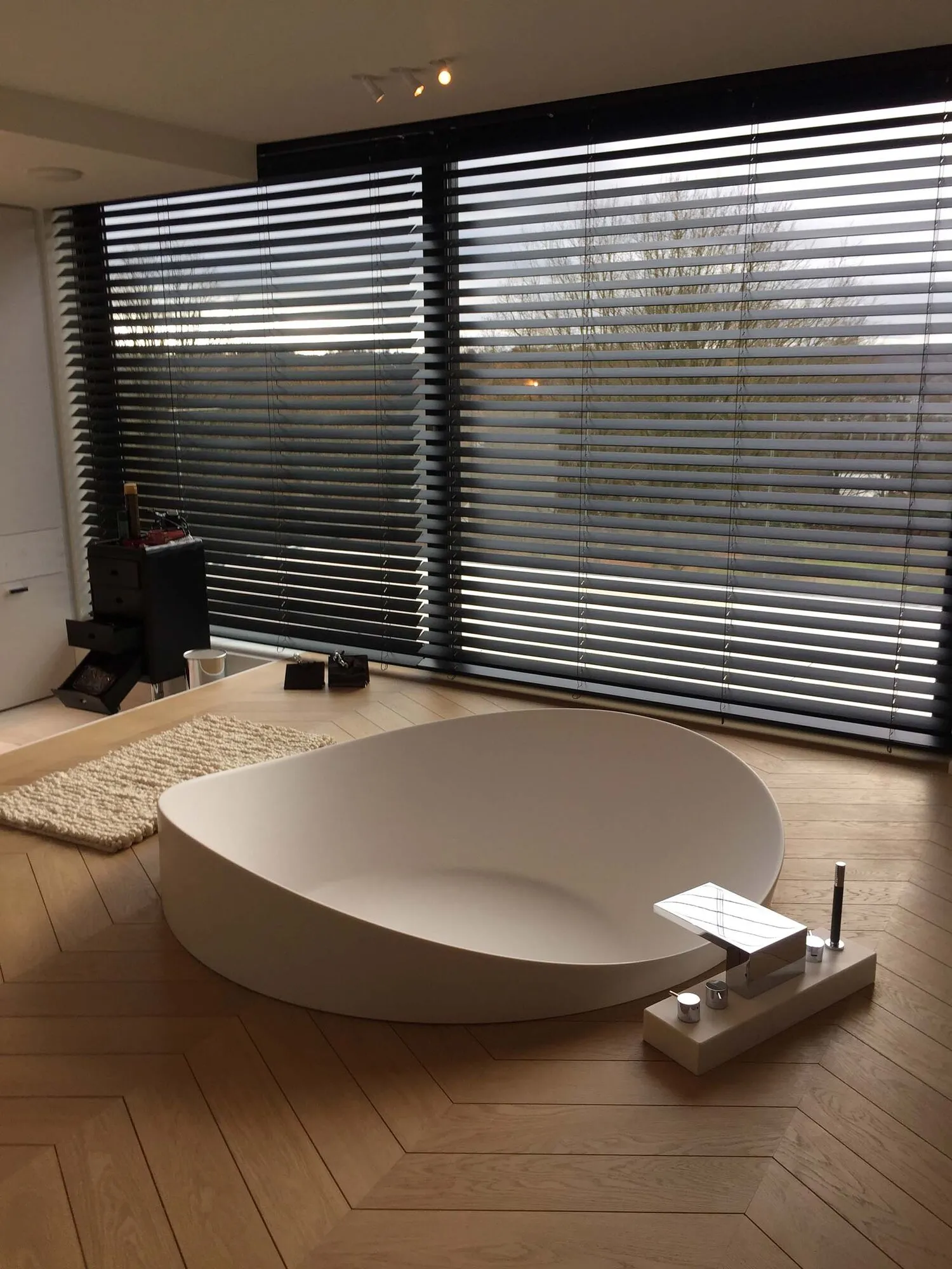 Zwarte jaloezieën voor brede ramen in een moderne badkamer